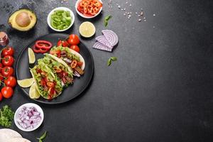 tacos mexicains avec boeuf, tomates, avocat, oignon et sauce salsa photo