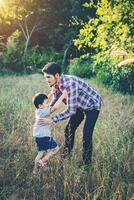 papa serrant son petit garçon dans ses bras. famille marchant dans le domaine. en plein air. photo