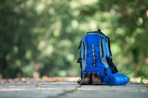 sac à dos et chaussures les routards se reposent sur la route lors d'une randonnée. photo