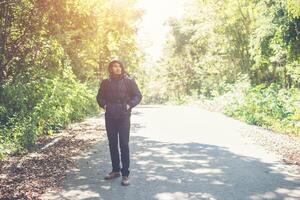 homme de randonneur marchant sur la route rurale. concept de tourisme de vacances. photo