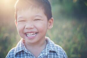 gros plan d'un garçon asiatique mignon jouant et souriant à l'extérieur. photo