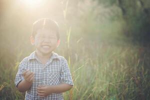 heureux petit garçon asiatique jouant à l'extérieur. mignon asiatique. garçon sur le terrain. photo