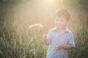 heureux petit garçon asiatique jouant à l'extérieur. mignon asiatique. garçon sur le terrain. photo