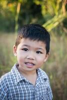 gros plan d'un garçon asiatique mignon jouant et souriant à l'extérieur. photo