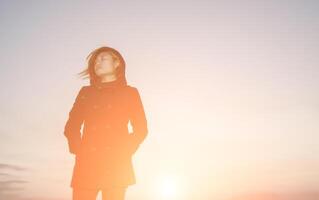 portrait de femme triste debout seule avec le coucher du soleil si solitaire photo