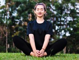 femme méditant et pratiquant le yoga dans la forêt photo