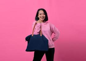 Portrait d'une jeune femme asiatique heureuse tenant un sac lors de ses achats photo