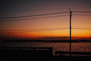 pylônes électriques avec câble et lampadaire au coucher du soleil. photo