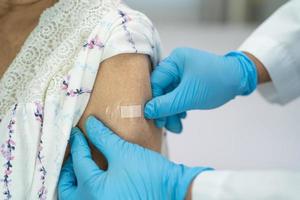 femme âgée asiatique âgée recevant un vaccin contre le covid-19 ou le coronavirus photo