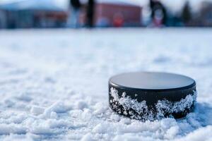 noir le hockey palet mensonges sur la glace à stade photo