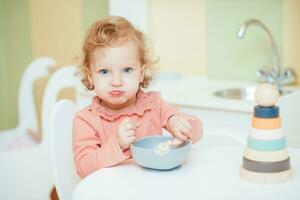 peu bébé mange Pâtes dans le enfants cuisine photo