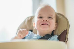 bébé séance sur une chaise et en riant maman photo