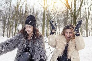 content mère et fille lancement neige dans le air dans le parc photo