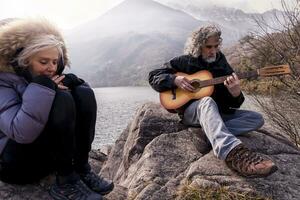 magnifique mature couple en jouant une guitare séance sur le Lac photo