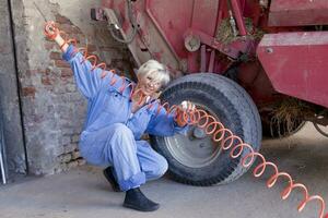 mécanique mature femelle gonfle le pneu de le tracteur photo