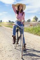 jolie Jeune femme sur bicyclette dans une pays route photo