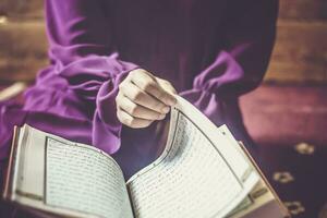 prier Jeune musulman femme. milieu est fille prier et en train de lire le saint coran. musulman femme en train d'étudier le coran photo