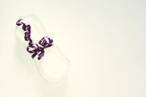 une sanitaire tampon lié avec ruban sur le rose Contexte. médecine, femmes santé et ovulation concept photo
