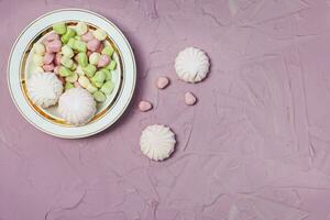 assiette de guimauves sur rose Contexte. coloré guimauve bonbons avec copie espace photo