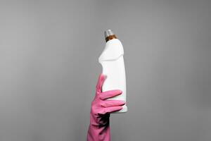 femelle main dans caoutchouc gants en portant nettoyage la fourniture ou désinfectant bouteille photo