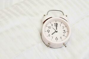 alarme l'horloge sur blanc lit photo