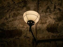 vieux ancien lampe sur le mur de une prison arrière-plan, sombre lumière photo