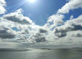 cargaison navire dans le ouvert mer. blanc des nuages et mer Contexte photo