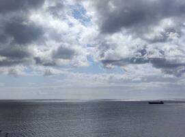 cargaison navire dans le ouvert mer. blanc des nuages plus de une orageux ciel Contexte et mer photo