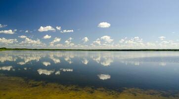 des nuages reflétant dans pur Lac l'eau photo