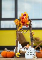 l'automne décor sur porche de Jaune maison à l'extérieur de citrouille, lanterne, guirlandes et figure de Accueil et clé. Halloween faire la fête, l'automne humeur, récolte festival, réel domaine, assurance, hypothèque photo