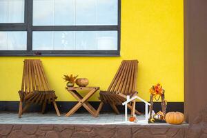 l'automne décor sur porche de Jaune maison à l'extérieur de citrouille, lanterne, guirlandes et figure de Accueil et clé. Halloween faire la fête, l'automne humeur, récolte festival, réel domaine, assurance, hypothèque photo