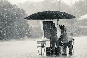 deux les personnes supporter lutte sur obstacles pluie torrentielle photo