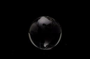 une noir et blanc photo de une globe sur une noir Contexte