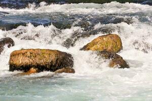 une groupe de rochers dans le l'eau photo