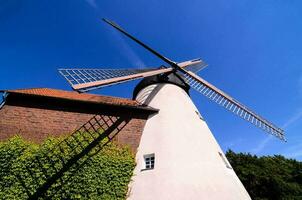 une Moulin à vent est montré contre une bleu ciel photo