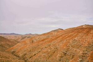 le montagnes sont rouge et marron avec certains des nuages dans le ciel photo