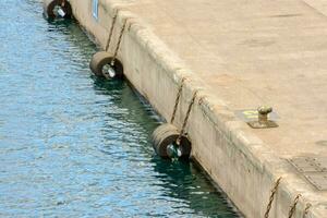 une rangée de pneus séance sur le bord de une Dock photo