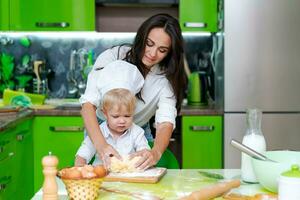 content mère et fils dans le cuisine et fabrication pâte, famille cuisine concept photo