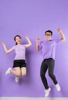 jeune couple asiatique sautant sur fond violet photo