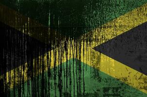 Jamaïque drapeau représenté dans peindre couleurs sur vieux et sale pétrole baril mur fermer. texturé bannière sur rugueux Contexte photo
