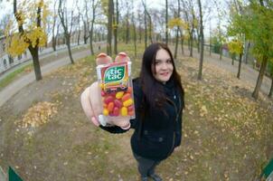 Kharkov, Ukraine - octobre 26, 2019 Jeune femme spectacles Nouveau tic tac difficile bonbons à la menthe paquet dans l'automne parc. tic tac est populaire dû ses menthe Frais goût par Ferrero photo