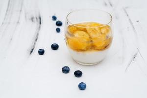 gelée de fruits colorés dans un verre sur fond blanc avec des bleuets photo