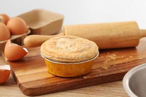 femme tenir la tarte à la viande sur un plateau en bois photo