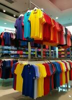 rangée de à la mode polo t-shirts pour homme sur en bois cintre ou grille dans une Vêtements boutique vente au détail magasin concept par ai généré photo