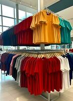 rangée de à la mode polo t-shirts pour homme sur en bois cintre ou grille dans une Vêtements boutique vente au détail magasin concept par ai généré photo