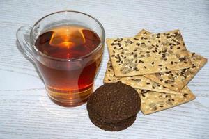 tasse en verre avec du thé chaud et des biscuits photo