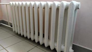 radiateur de chauffage intérieur. des radiateurs en fonte chauffent la pièce. photo