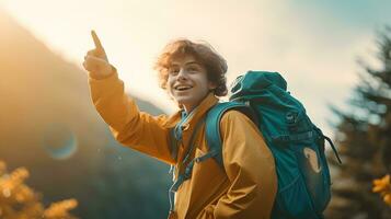 content garçon promeneur avec sac à dos montrer du doigt doigt à copie espace dans montagnes photo