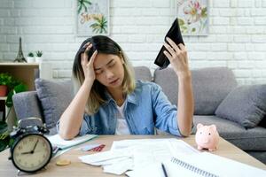 sans emploi asiatique femme ouverture un vide portefeuille. elle a été stressé car elle n'a pas avoir argent à Payer sa dettes à maison. photo