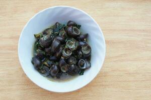 kaeng hoi khom, escargots de rivière ou curry de pervenche sur bol blanc. concept , escargots comestibles pouvant être cuisinés dans divers menus délicieux. la nourriture bizarre. cuisine locale traditionnelle thaïlandaise. photo